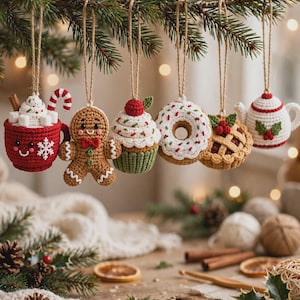Può includere: Sei decorazioni natalizie all'uncinetto appese a un ramo di pino. Il set include una tazza rossa con marshmallow e un bastoncino di zucchero, un omino di pan di zenzero, un cupcake, una ciambella, una tortina e una teiera bianca con agrifoglio.