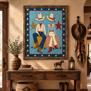 May include: A framed wall art piece featuring two headless figures wearing cowboy hats, shirts, and pants, sitting on blocks against a light blue background. The border is dark blue with white stars, and gold and red stars flank the figures.