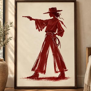 May include: A framed wall art print featuring a dark red ink sketch of a figure wearing a wide-brimmed hat, a long-sleeved top, and flared trousers. The figure holds a revolver in one hand and a coiled rope in the other, set against a cream background.