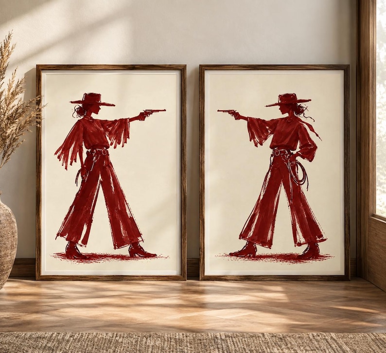 May include: Two framed wall art prints featuring a dark red sketch of a figure wearing a wide-brimmed hat, a long-sleeved top with fringe, and wide-leg trousers. The figure is shown in profile, holding a handgun with an outstretched arm.