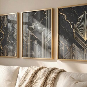 May include: Three rectangular wall art prints in thin gold frames, featuring a black marble background with intricate, symmetrical gold geometric line patterns. The prints are arranged side-by-side on a light-colored wall above a sofa.