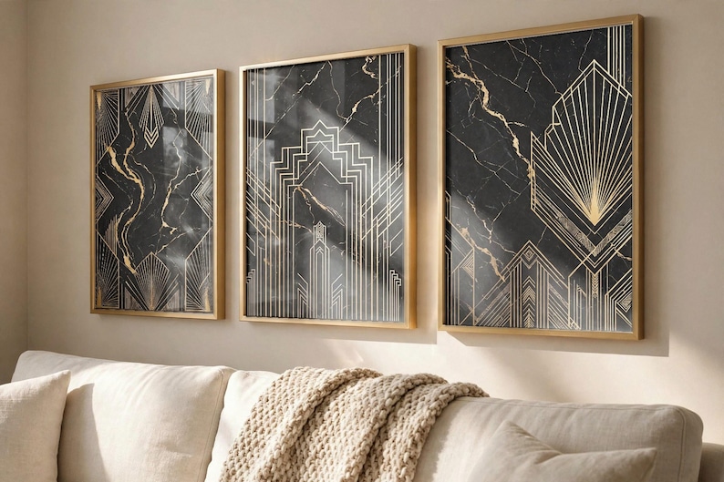 May include: Three rectangular wall art prints in thin gold frames, featuring a black marble background with intricate, symmetrical gold geometric line patterns. The prints are arranged side-by-side on a light-colored wall above a sofa.