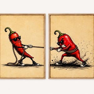 May include: Two framed wall art prints featuring a red chilli pepper character in each. The left chilli wears sunglasses and pulls a rope. The right chilli wears sunglasses, has an angry expression, and pulls the rope, creating dust and debris.