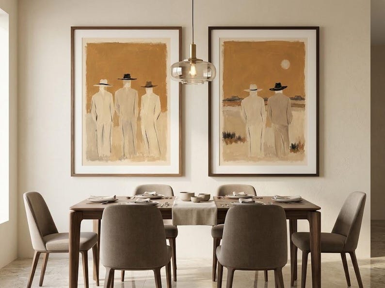 May include: Two framed wall art prints featuring abstract figures in hats against a warm ochre background. The left print shows three figures, while the right print depicts two figures in a landscape. Both are displayed in dark wood frames.