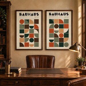 K&ouml;nnte beinhalten: Zwei gerahmte Kunstdrucke mit dem Text BAUHAUS GEOMETRIC ART PRINT SEPT 1919 am oberen Rand. Jeder Druck zeigt ein Raster aus geometrischen Formen wie Kreisen, Halbkreisen und Quadraten in den Farben Orange, Dunkelgr&uuml;n, Braun und Beige.