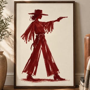 May include: A framed wall art print featuring a dark red ink-style illustration of a figure wearing a wide-brimmed hat, a fringed top, and wide-leg trousers. The figure is depicted in profile, holding a revolver with an outstretched arm.