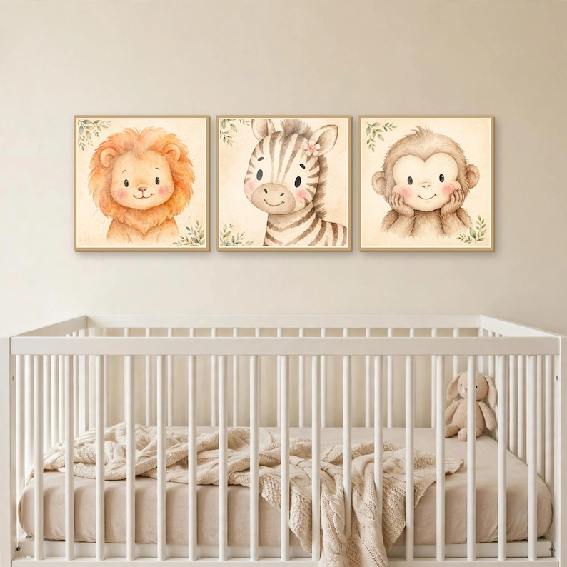K&ouml;nnte beinhalten: Drei quadratische Wandbilder mit Aquarellillustrationen eines L&ouml;wen, eines Zebras und eines Affen. Jedes Tier ist mit weichen Gesichtsz&uuml;gen, rosigen Wangen und kleinen gr&uuml;nen Blattakzenten auf einem hellen cremefarbenen Hintergrund dargestellt.