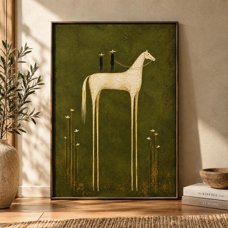 May include: A framed wall art print featuring a tall, slender, cream-colored horse with elongated legs standing on a dark olive green background. Two small figures wearing wide-brimmed hats stand on the horse's back, with thin flowers below.