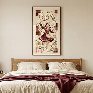 Dancing cowgirl folk art print above a bed with a wooden headboard and burgundy throw — cowgirl bedroom wall art, digital download