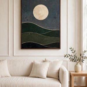 Dark green moon landscape art print framed above a cream sofa in a living room — Japandi printable wall art for a calm, modern space