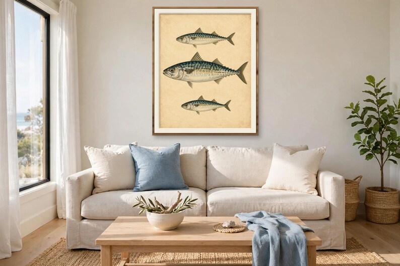 Antique fish print in a wood frame above a linen sofa in a coastal living room — vintage mackerel illustration wall art for beach house and lake house decor