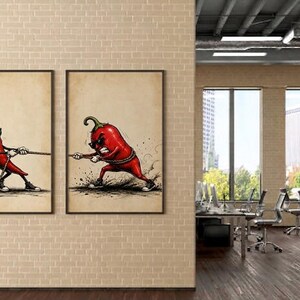 May include: Two framed wall art prints featuring a red chilli pepper character wearing sunglasses and trainers. The left print shows the chilli pulling a rope, while the right print shows the chilli straining with a determined expression while tugging.