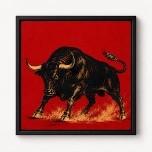 May include: A framed square wall art piece featuring a detailed black ink illustration of a charging bull with light-colored horns. The bull is positioned against a solid, vibrant red background with golden-yellow dust effects at its hooves.