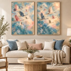May include: Two rectangular wall art prints featuring a flock of birds in flight against a soft, blended background of blue, pink, and cream clouds. The birds are depicted in shades of white, grey, and pink, captured in various wing positions.