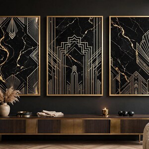 Puede incluir: Un conjunto de tres láminas de arte mural rectangulares con fondos de mármol negro y patrones de líneas geométricas doradas, cada una en un marco dorado fino. Las obras muestran diseños simétricos y angulares con motivos de abanico.