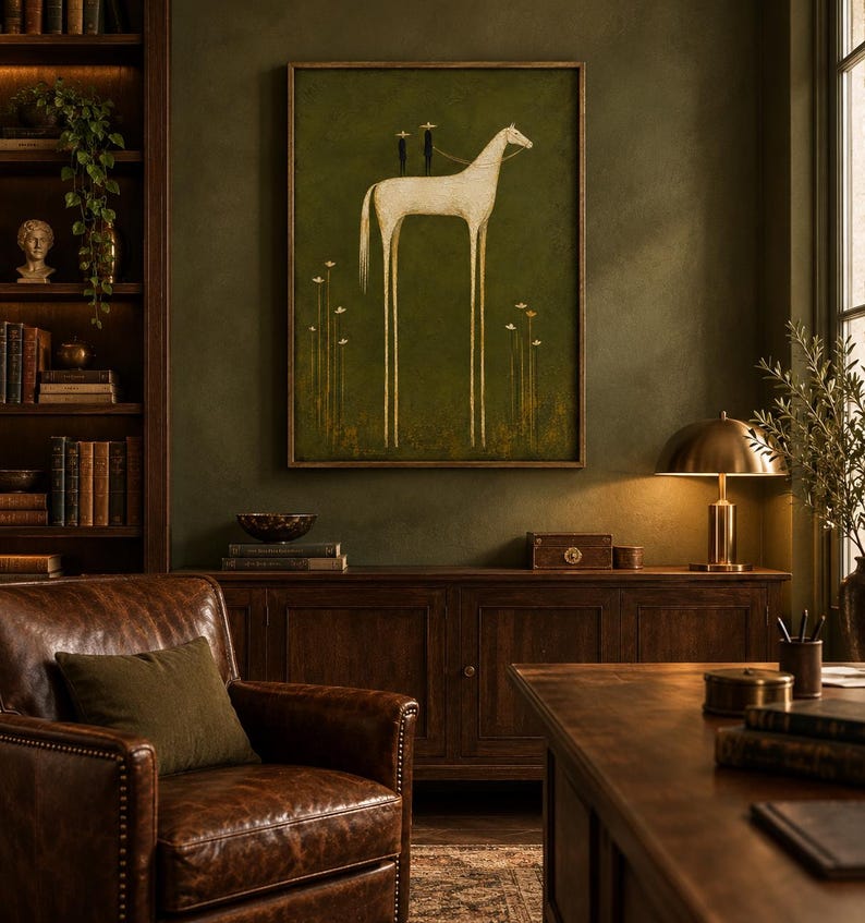 May include: A framed wall art print featuring a tall, slender white horse with elongated legs standing on a dark olive green background. Two small dark figures with star-shaped heads are positioned on the horse's back, surrounded by thin floral stems.