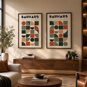 K&ouml;nnte beinhalten: Zwei gerahmte Kunstdrucke mit dem Text BAUHAUS GEOMETRIC ART PRINT. Jeder Druck zeigt ein Raster aus Kreisen, Halbkreisen und Quadraten in Dunkelgr&uuml;n, gebranntem Orange, Beige und Braun auf einem cremefarbenen Hintergrund.