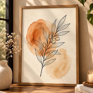 May include: A framed wall art print featuring a black line drawing of an olive branch with leaves and small olives centered over two overlapping watercolor circles in shades of burnt orange and light tan on a cream-colored background.