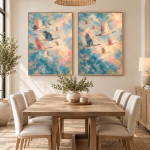 May include: Two rectangular wall art prints featuring a flock of birds in flight against a soft, blended sky of blue, pink, and cream tones. Each piece is encased in a thin, light-colored wooden frame, displaying a painterly texture.