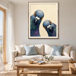 May include: A framed wall art print featuring two pigeons with iridescent blue, green, and purple neck feathers and bright orange eyes, set against a textured cream-coloured background, displayed in a simple wooden frame.