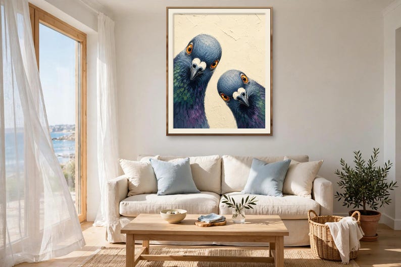 May include: A framed wall art print featuring two pigeons with iridescent blue, green, and purple neck feathers and bright orange eyes, set against a textured cream-coloured background, displayed in a simple wooden frame.