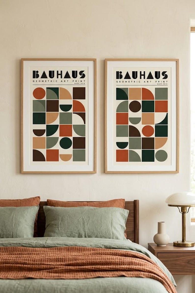 K&ouml;nnte beinhalten: Zwei gerahmte Kunstdrucke mit dem Text BAUHAUS GEOMETRIC ART PRINT. Jeder Druck zeigt ein Raster aus geometrischen Formen wie Kreisen, Halbkreisen und Quadraten in einer Farbpalette aus Dunkelgr&uuml;n, Rostorange, Braun und Beige.