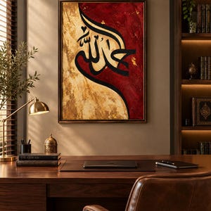 K&ouml;nnte beinhalten: Ein rechteckiges Wandbild mit schwarzer arabischer Kalligrafie, zentriert auf einem geteilten Hintergrund aus strukturiertem Dunkelrot und Metallic-Gold. Das Kunstwerk ist in einem d&uuml;nnen dunklen Rahmen gefasst und zeigt einen starken Kontrast zwischen der dunklen Schrift und dem lebendigen, geschichteten Farbauftrag auf der Leinwand.