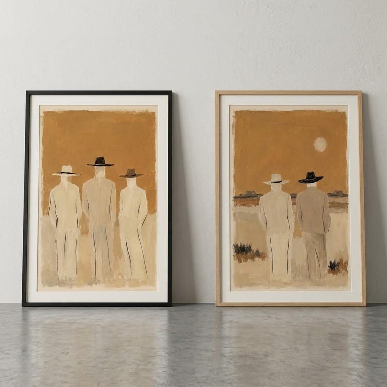 May include: Two framed wall art prints featuring painted figures in hats. The left print shows three figures in light suits and dark hats against a tan background. The right print shows two figures in light suits and hats looking toward a horizon with a sun.