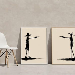 Pu&ograve; includere: Due stampe artistiche da parete incorniciate con sagome a inchiostro nero di figure che indossano cappelli a tesa larga e cappotti lunghi. Ogni figura &egrave; di profilo e punta una pistola verso l'altra su uno sfondo beige chiaro.