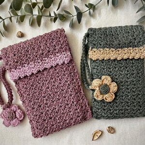 May include: Two rectangular crochet pouches with wrist straps. One pouch is dusty rose with a lighter pink trim and a matching flower charm. The other is dark forest green with a beige trim and a beige crochet flower attached to the front.
