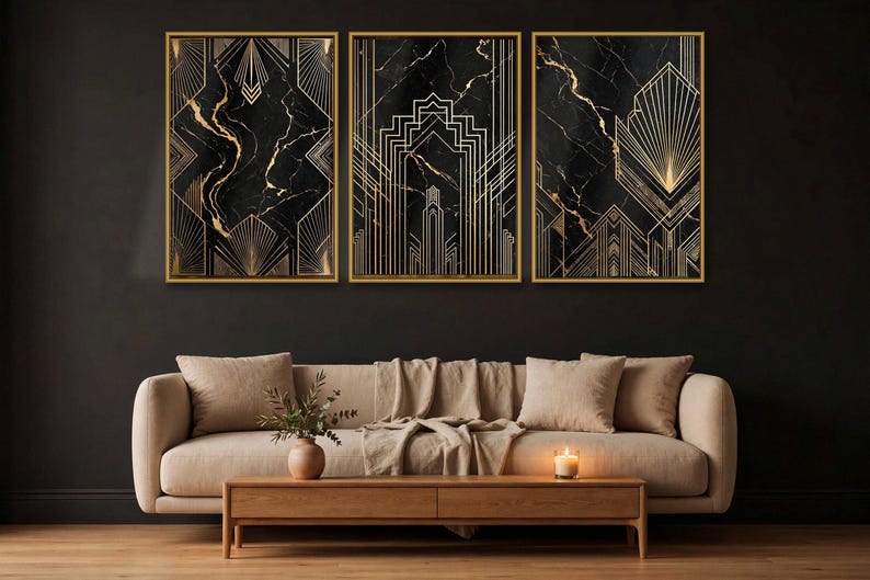 May include: A set of three rectangular wall art prints featuring black marble backgrounds with gold geometric line patterns, each encased in a thin gold frame. The prints are displayed side by side on a dark wall above a beige sofa.