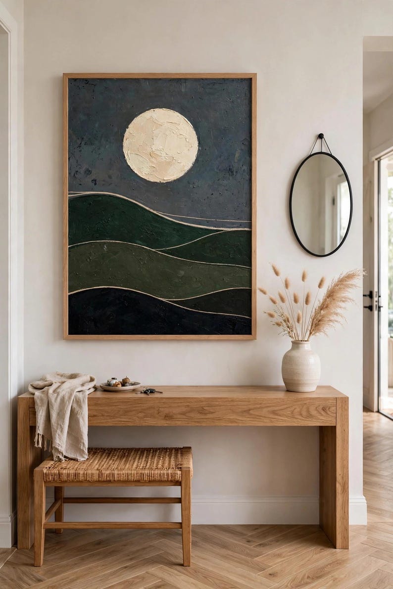 Framed Japandi landscape print with cream moon and dark green hills above a wooden console in an entryway — printable wall art