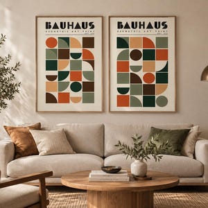 K&ouml;nnte beinhalten: Zwei gerahmte Kunstdrucke mit dem Text BAUHAUS GEOMETRIC ART PRINT. Jeder Druck zeigt ein Raster aus geometrischen Formen wie Kreisen, Halbkreisen und Quadraten in einer Farbpalette aus gebranntem Orange, Dunkelgr&uuml;n, Braun und Beige.