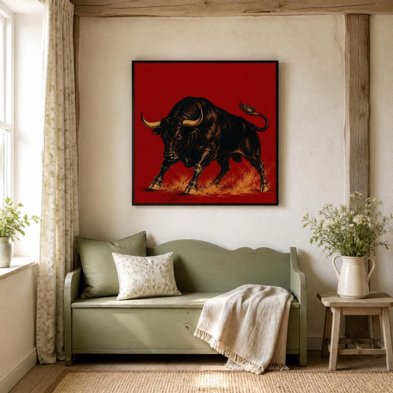 May include: A square wall art print featuring a detailed black bull illustration against a solid red background. The bull is depicted in a charging stance with golden-toned horns and hooves, with stylized orange dust clouds swirling beneath its feet.