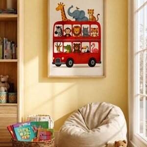 May include: A framed wall art print featuring a bright red double-decker bus filled with various illustrated animals, including a giraffe, elephant, zebra, lion, monkey, crocodile, bear, toucan, and flamingo, all looking out of the bus windows.