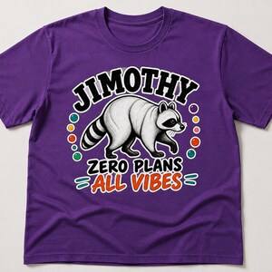 May include: A purple short-sleeved t-shirt featuring a graphic of a raccoon in the centre. Above the raccoon is the text JIMOTHY in black letters. Below the raccoon is the text ZERO PLANS ALL VIBES in black and orange letters with colourful dots.