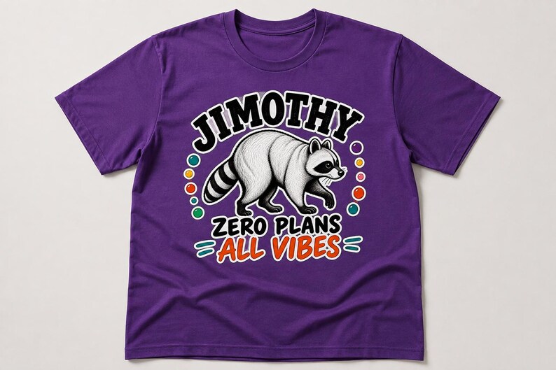 May include: A purple short-sleeved t-shirt featuring a graphic of a raccoon in the centre. Above the raccoon is the text JIMOTHY in black letters. Below the raccoon is the text ZERO PLANS ALL VIBES in black and orange letters with colourful dots.