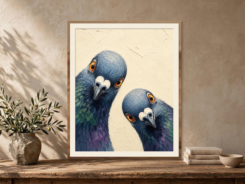 May include: A framed wall art print featuring an oil painting of two pigeons with iridescent blue, green, and purple neck feathers and bright orange eyes, set against a textured cream-coloured background with visible brushstrokes.
