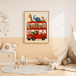 May include: A framed wall art print featuring a bright red double-decker bus filled with various illustrated animals, including a giraffe, elephant, tiger, zebra, monkey, lion, rhino, crocodile, bear, toucan, and flamingo, set against a cream background.