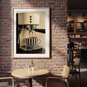 May include: A framed wall art print depicting a cream and black espresso machine brewing coffee into a black and white striped ceramic mug. The machine features a metallic portafilter, three circular buttons, and a steam wand, all set against a neutral background.