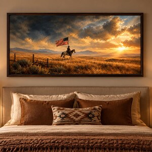 May include: A rectangular wall art print in a dark wood frame depicting a lone rider on horseback carrying an American flag across a golden prairie landscape at sunset, with dramatic clouds, distant mountains, and a wooden fence in the foreground.