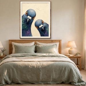 May include: A framed wall art print featuring two pigeons with iridescent blue, green, and purple neck feathers and bright orange eyes, set against a textured cream-coloured background, displayed above a bed in a bedroom setting.
