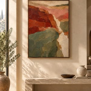 May include: A rectangular wall art piece featuring an abstract landscape painting with thick, textured brushstrokes in shades of deep red, muted green, soft pink, and cream, enclosed within a thin, dark brown wooden frame hanging on a wall.