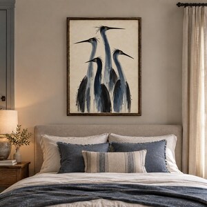 May include: A framed wall art print featuring a watercolour-style illustration of four blue herons standing together. The birds are depicted in shades of dark blue, grey, and black against a neutral, off-white background with visible brushstrokes.