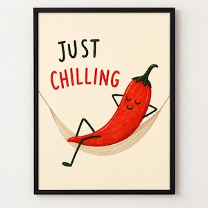 May include: A framed wall art print featuring a bright red chilli pepper with a smiling face, relaxing in a beige hammock. The text "JUST CHILLING" is printed in dark green and red letters above the chilli pepper on a cream-coloured background.