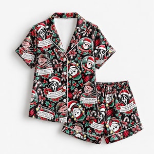 May include: A black short-sleeve button-down pajama shirt and matching shorts set featuring a holiday print of horror movie characters in Santa hats, candy canes, and holly. Text includes "What's your Christmas movie?" and "He sees you when you're sleeping."