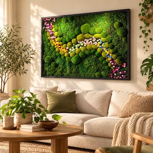 May include: A rectangular wall art piece featuring a dense arrangement of preserved green moss in various shades, accented by a winding path of small, colorful flowers in pink, yellow, white, and blue, all enclosed within a thin black frame.