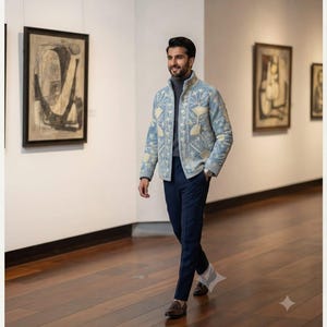 May include: A light blue jacket featuring intricate cream-colored Kashmiri embroidery, worn over a grey turtleneck sweater and dark blue trousers. The text at the top reads MAN IN KASHMIRI EMBROIDERY JACKET - COLLECTION PORTRAITS.