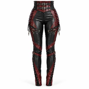 May include: High-waisted trousers in black and dark red featuring a corset-style waistband with two metal buckles, side lace-up detailing, and decorative metal rings with pointed accents. The legs have diagonal panels and lower leg lacing.