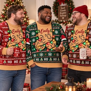 May include: Three knit jumpers featuring a tan centre panel with the name Emily, a graphic of two cookies, and integrated colourful string lights. The jumpers have red, green, and brown patterned sleeves and bodies with the text HO HO HO.